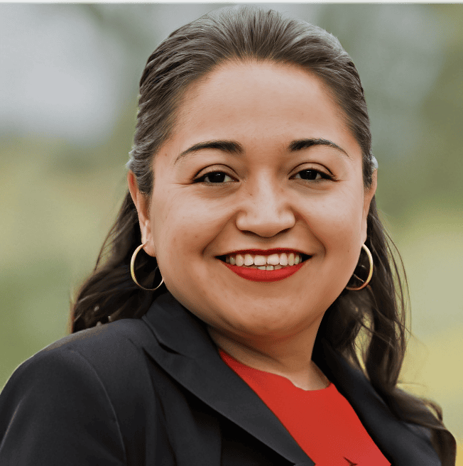Smiling person with red lipstick outdoors.