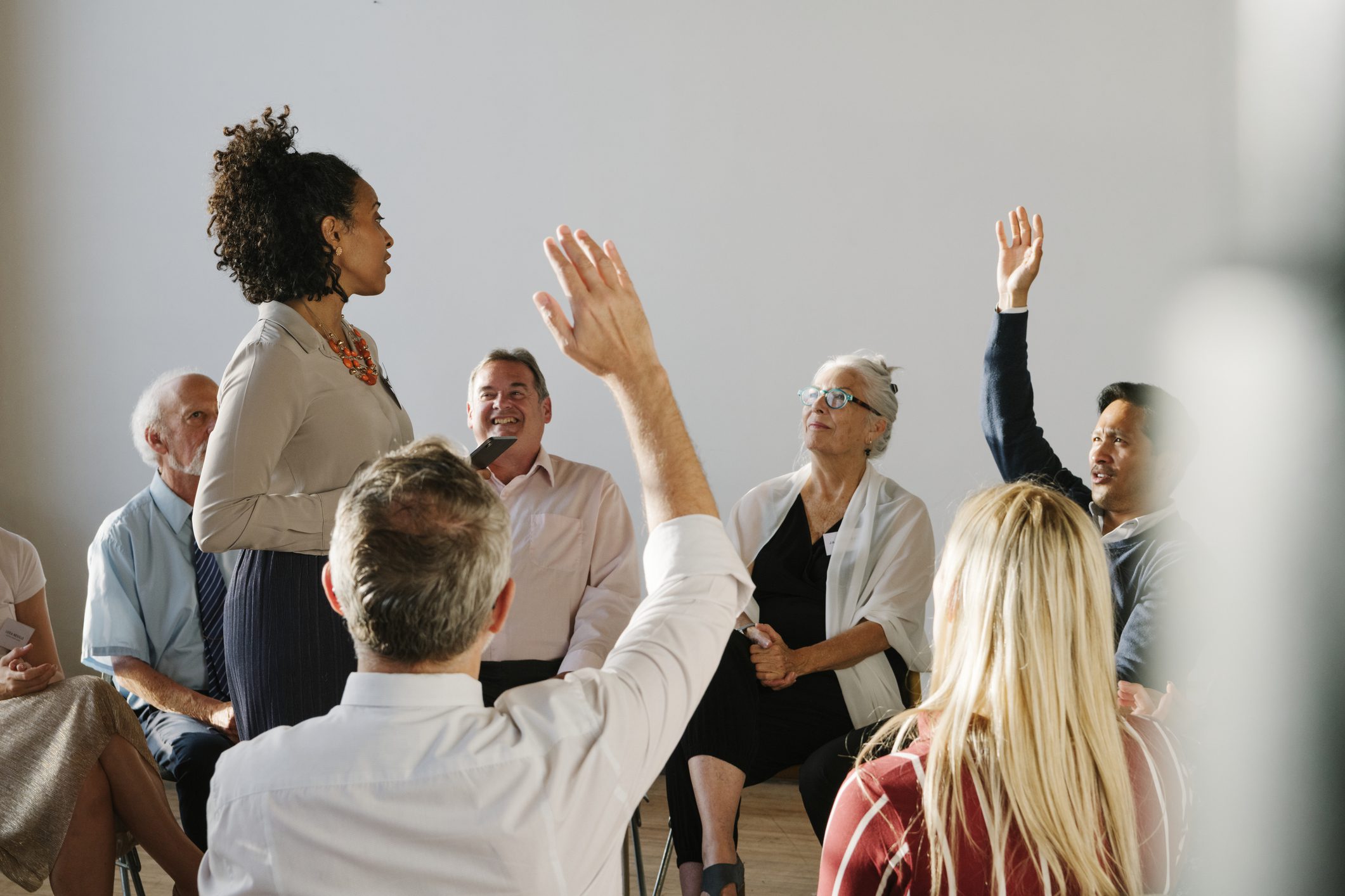 Group discussion with participants raising hands.