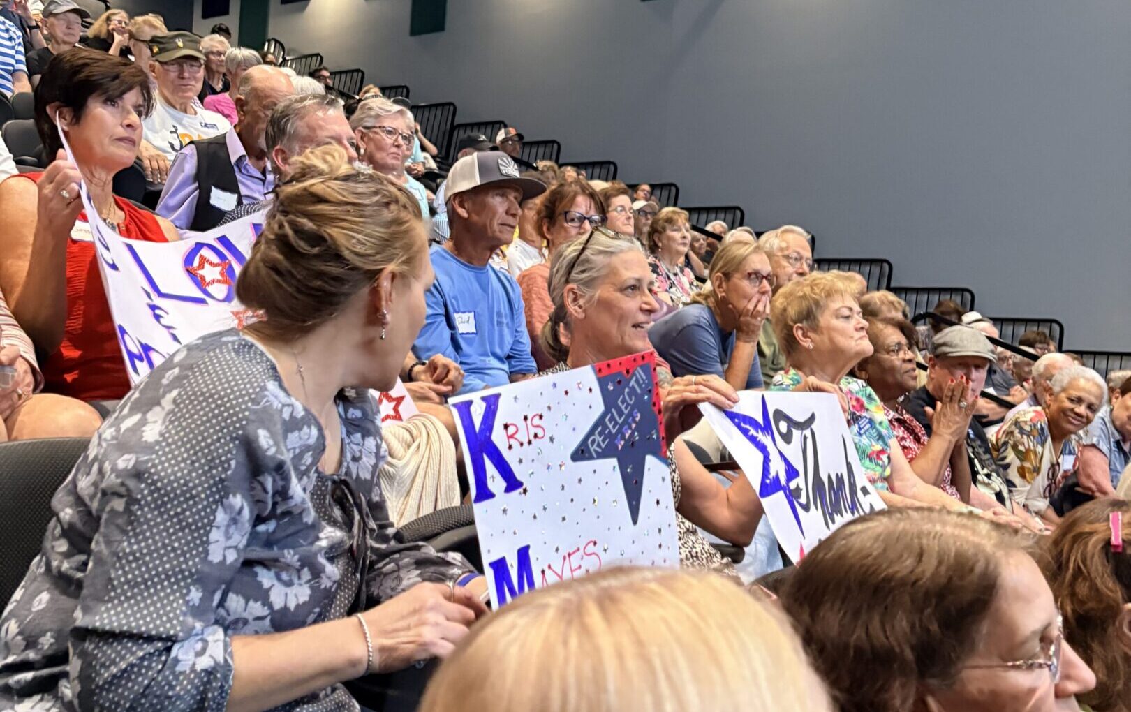 Audience members holding signs at an event.