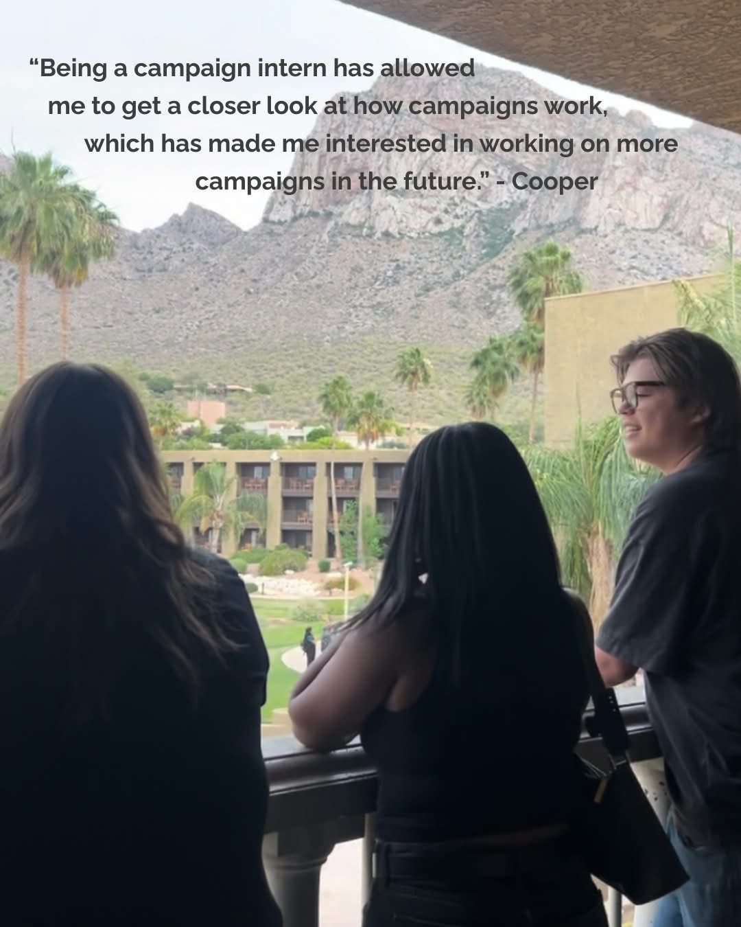 Three people overlooking a scenic mountain view.