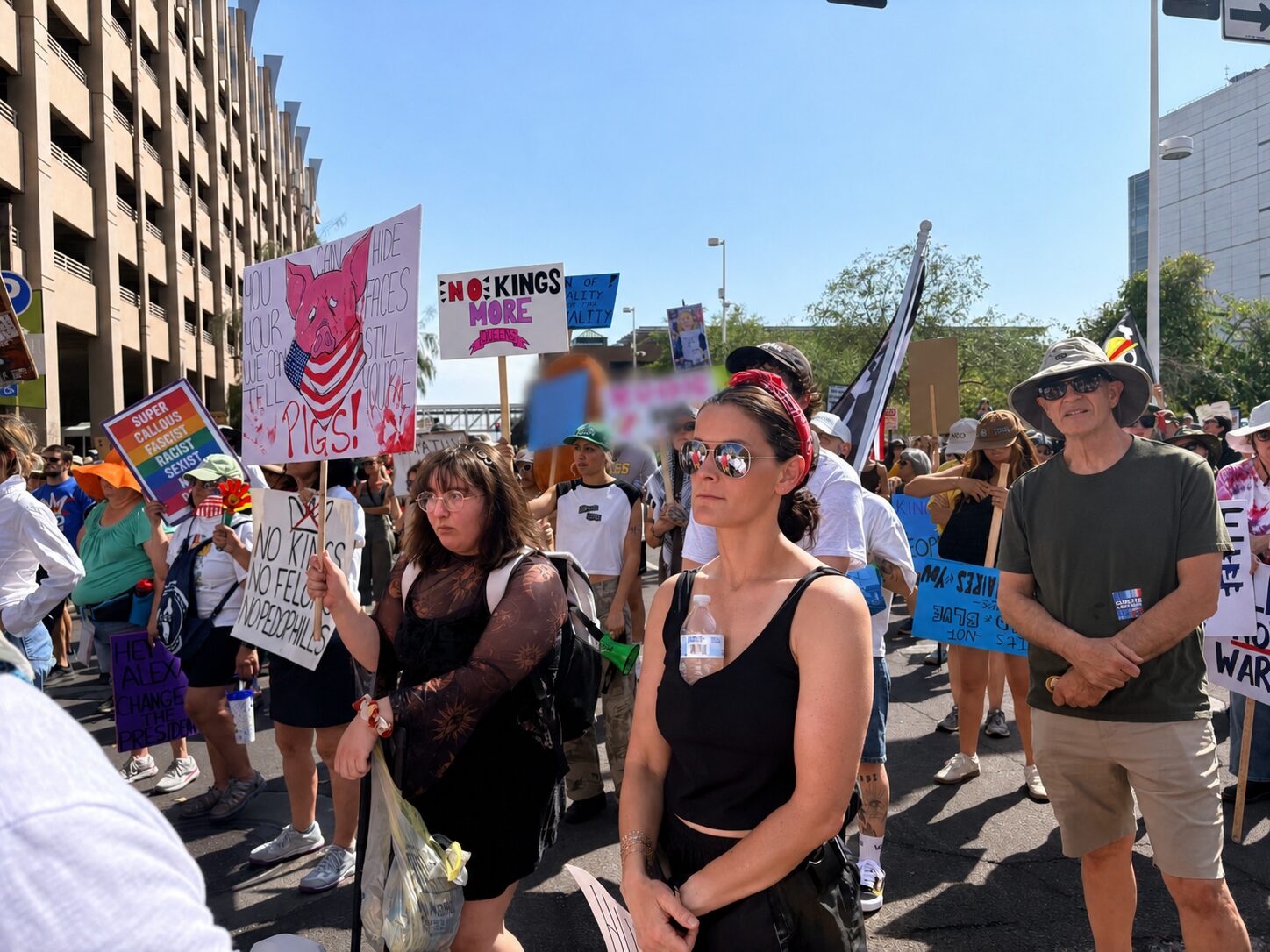 Protesters holding signs at a daytime rally.